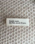 "GENTLE WASH, DRY FLAT, MEND IF TORN." - MERKELAPP