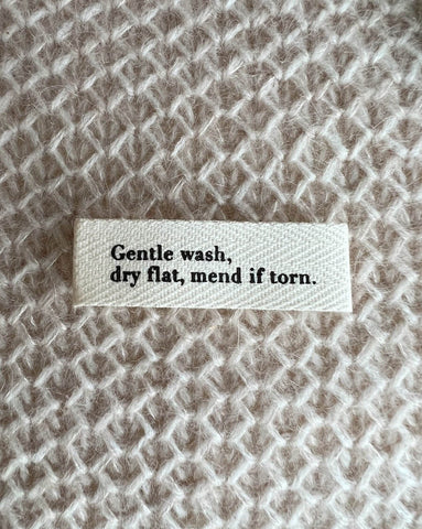 "GENTLE WASH, DRY FLAT, MEND IF TORN." - MERKELAPP